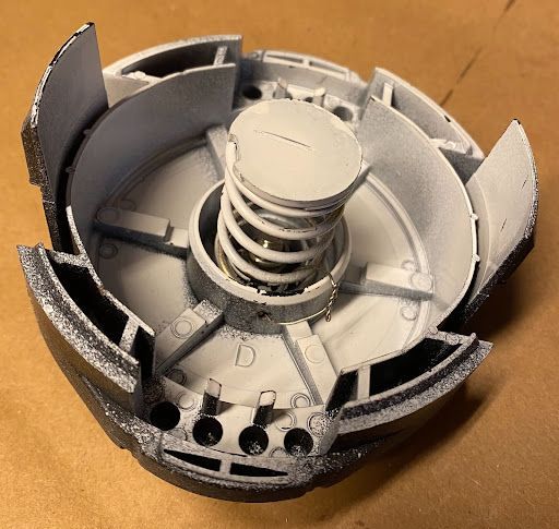 A broken piece of metal with a spring in the middle