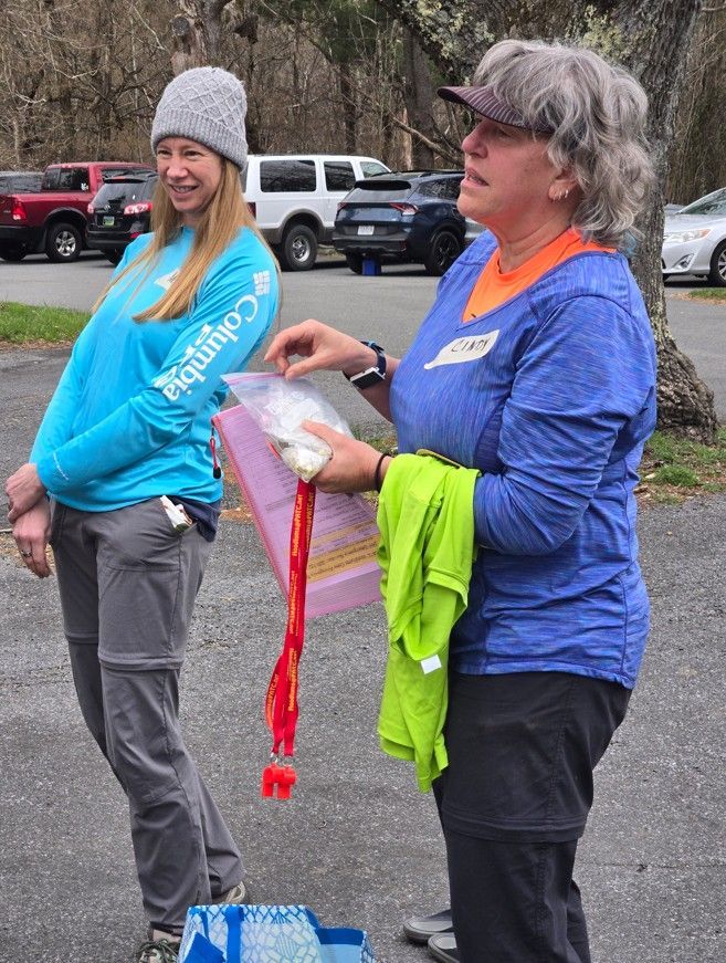 Two women are standing in a parking lot one is wearing a columbia shirt