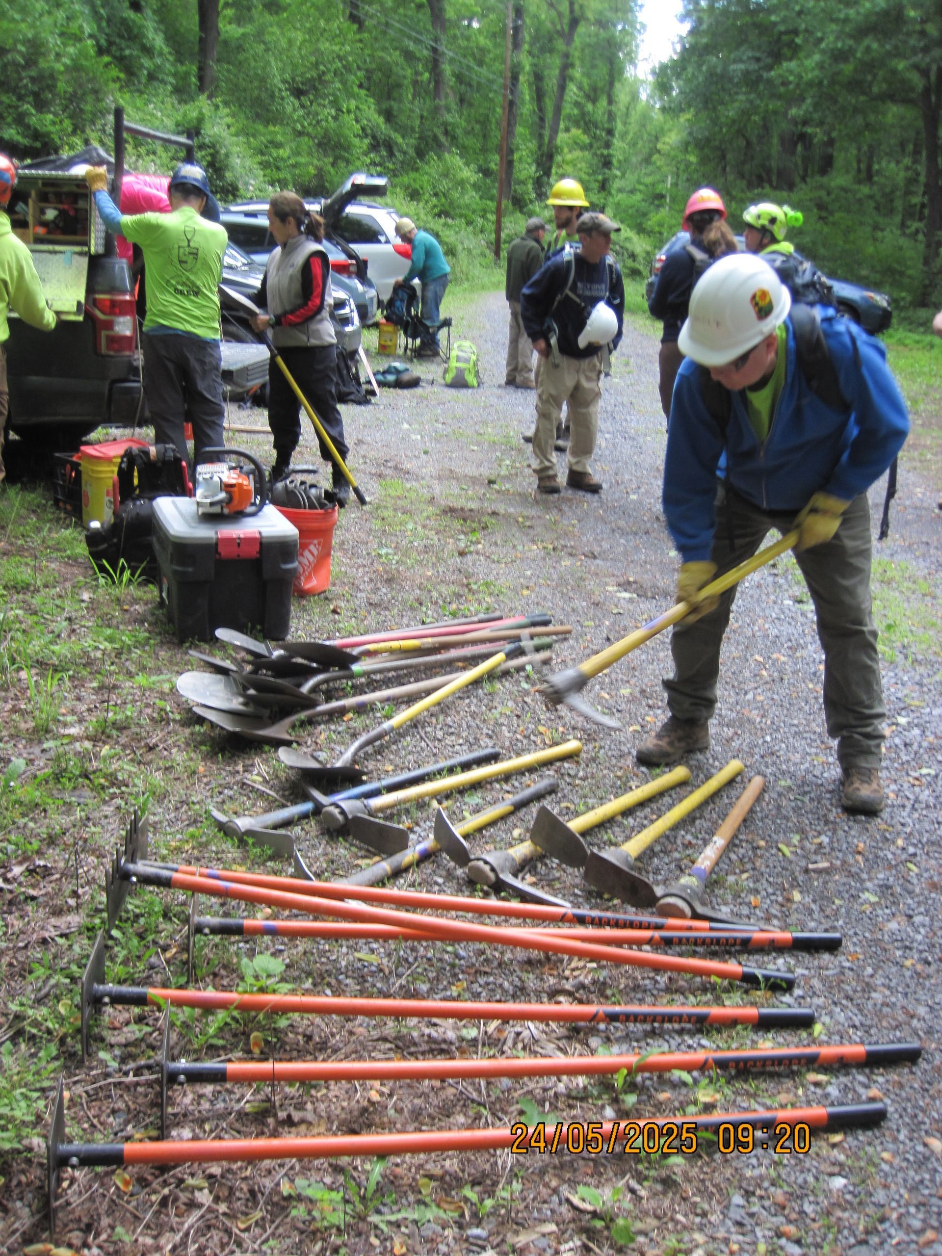 A man is standing in front of a pile of tools