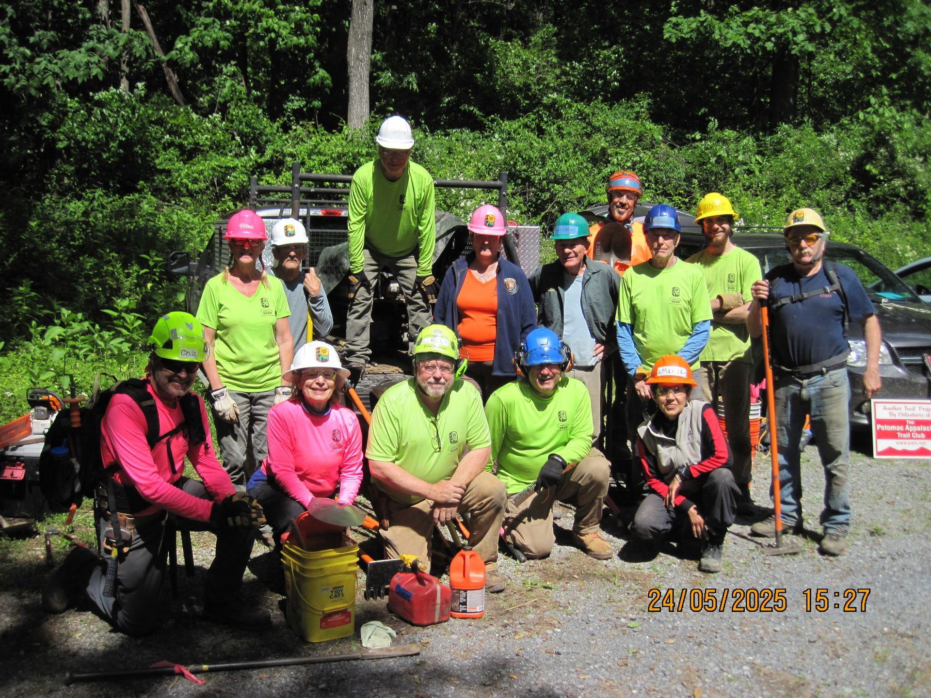 A group of people wearing hard hats pose for a picture