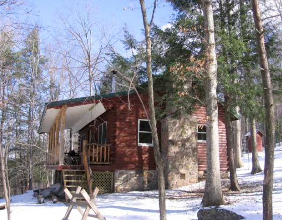 A red cabin in the middle of a snowy forest