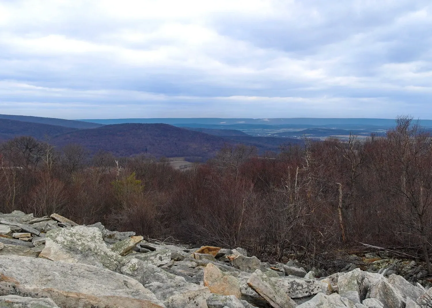 A view of a mountain range from a rocky hillside