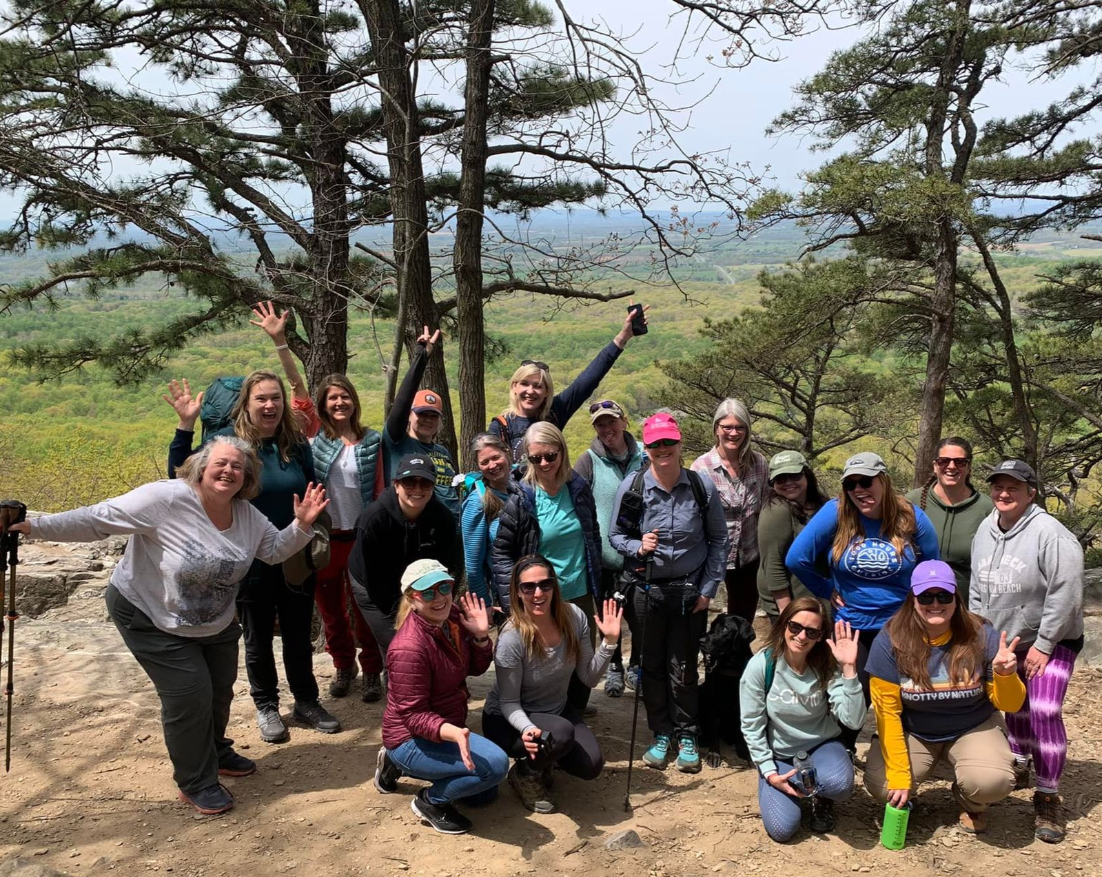 A group of women are posing for a picture on top of a mountain.