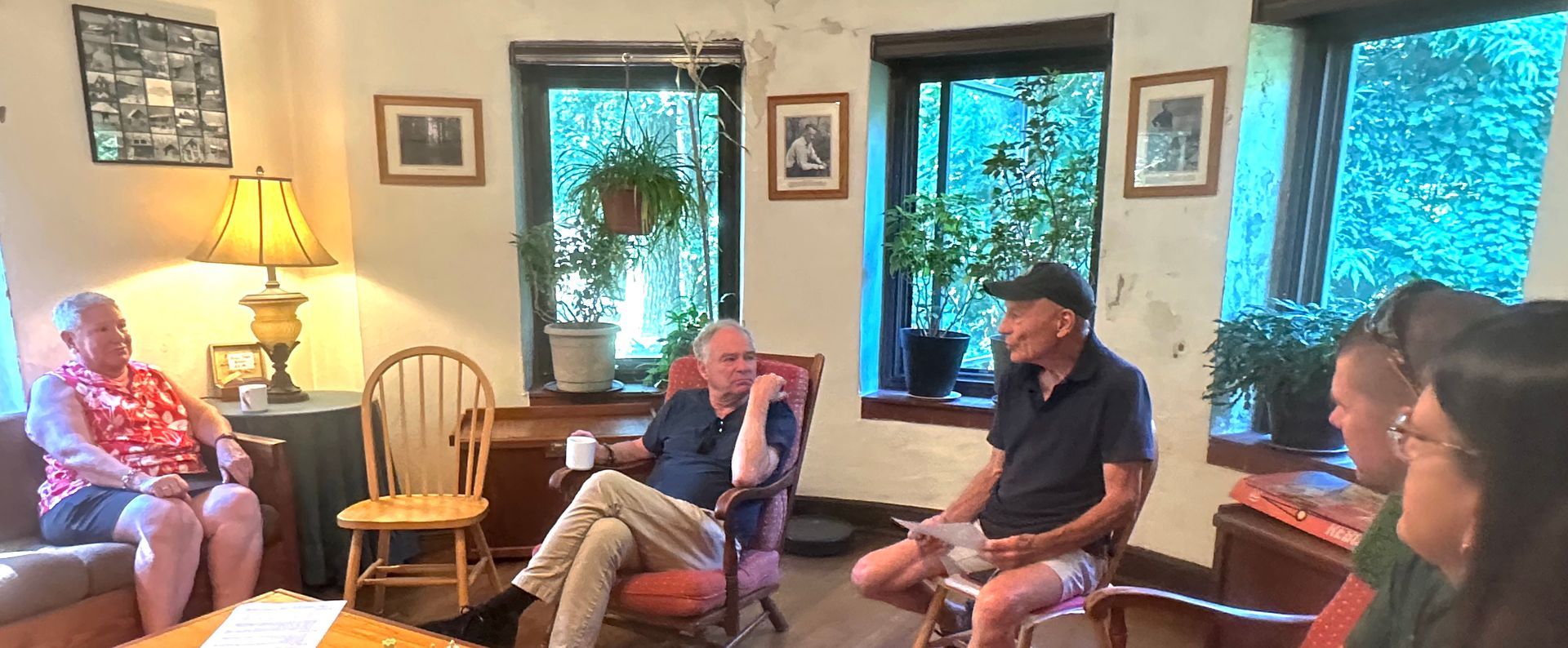 A group of people are sitting in chairs in a living room.