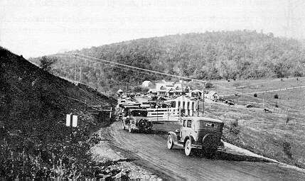 A black and white photo of a truck driving down a road.