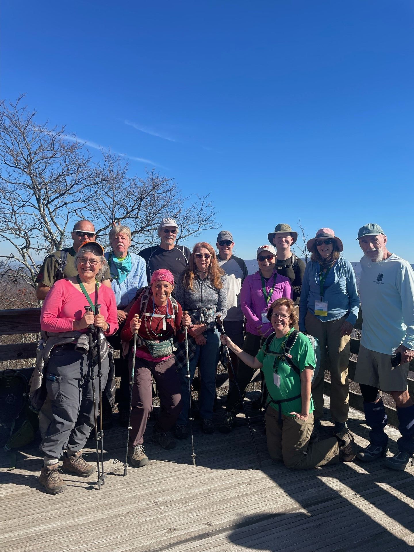 A group of people are posing for a picture on top of a mountain.