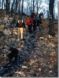A group of people are hiking up a rocky hill.