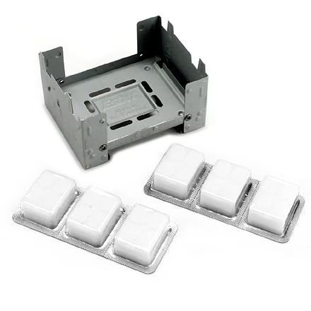 A small stove with four blocks of fuel inside of it.