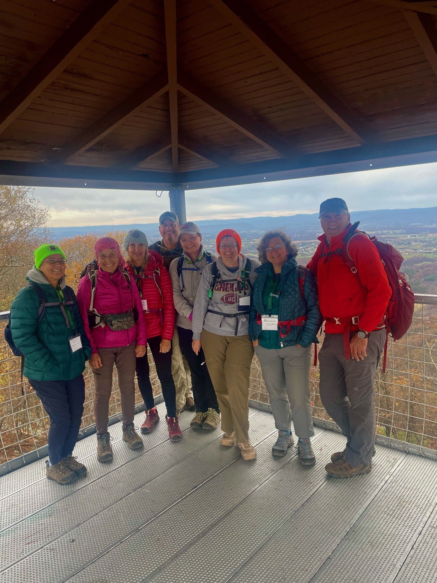 A group of people are posing for a picture on top of a gazebo.