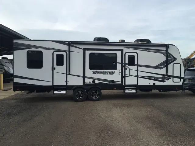 A white and black trailer is parked in a parking lot.