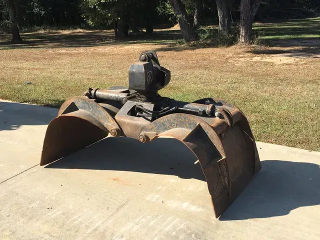 A large metal claw is sitting on a concrete surface.