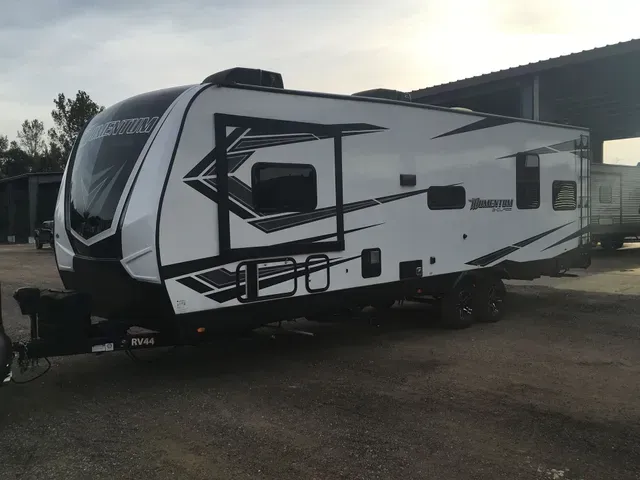 A white and black trailer is parked in a parking lot.