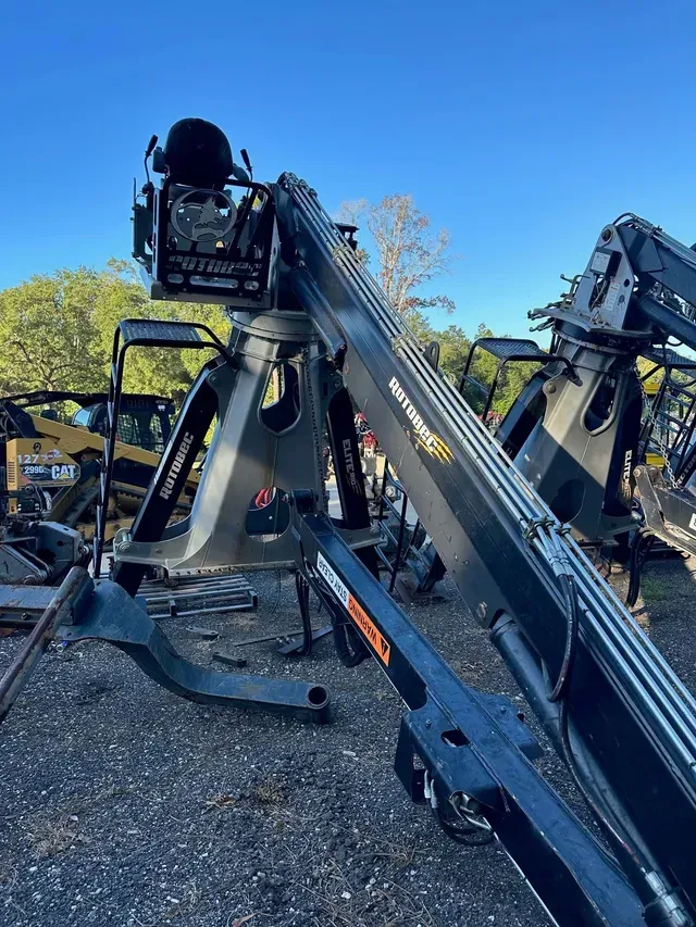 A large crane is sitting on top of a gravel lot.
