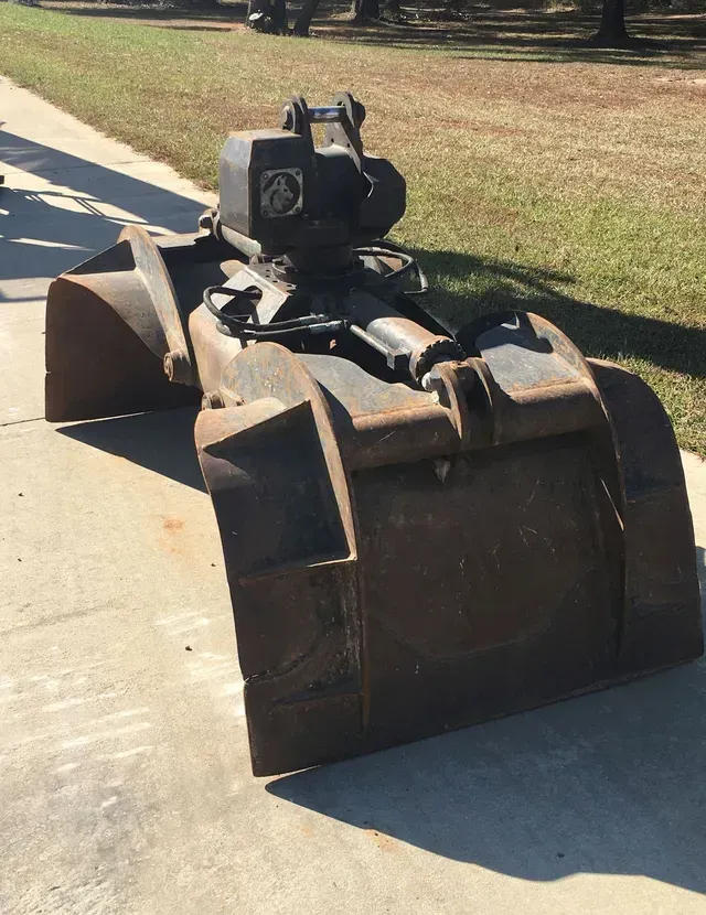 A large metal bucket is sitting on the sidewalk