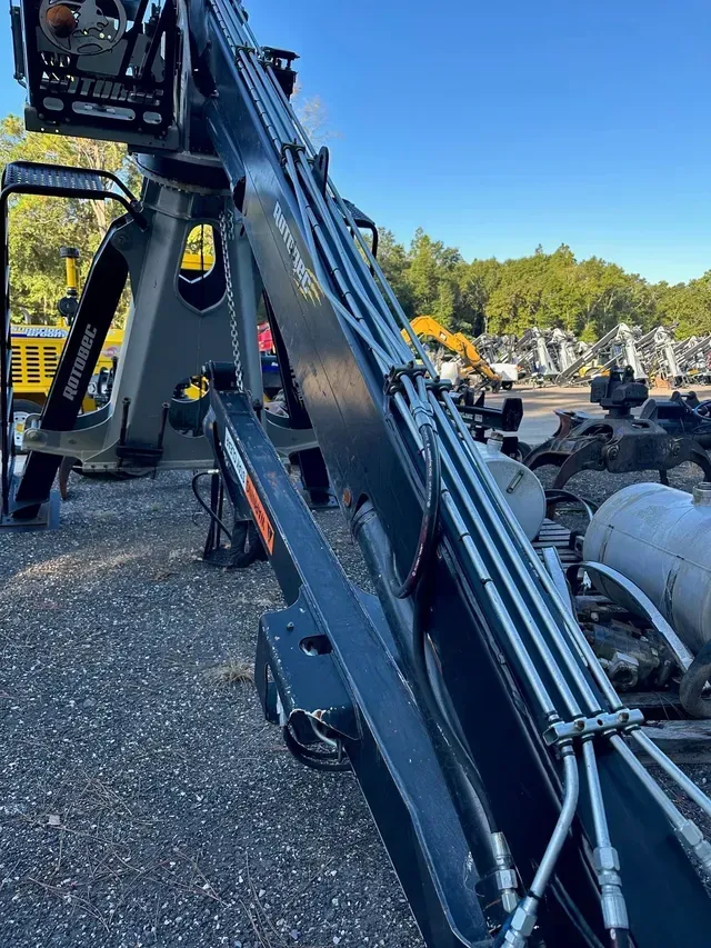 A large crane is sitting on top of a gravel lot.