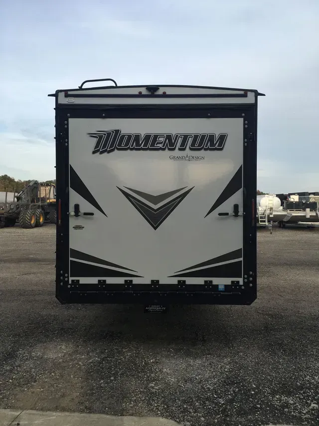 A momentum trailer is parked in a gravel lot