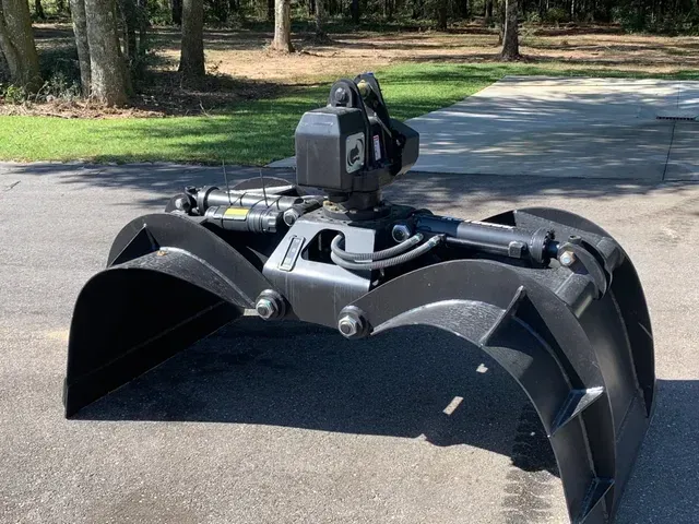 A large black claw is sitting on the side of a road.