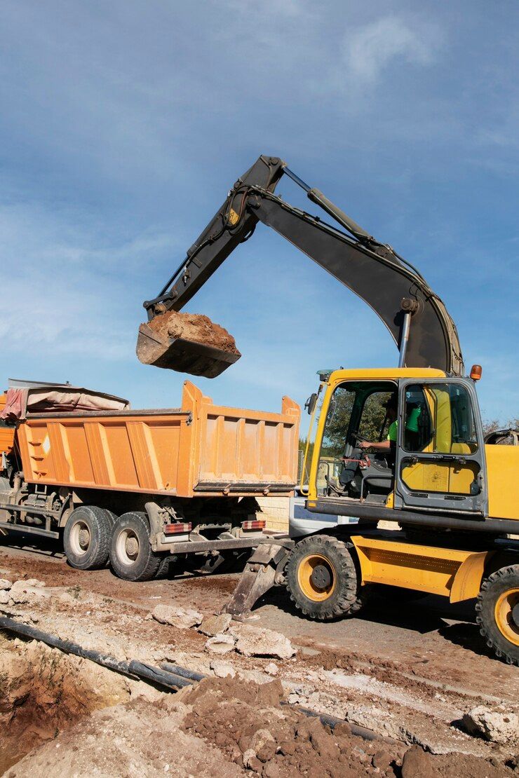 An excavator is loading dirt into a dump truck.