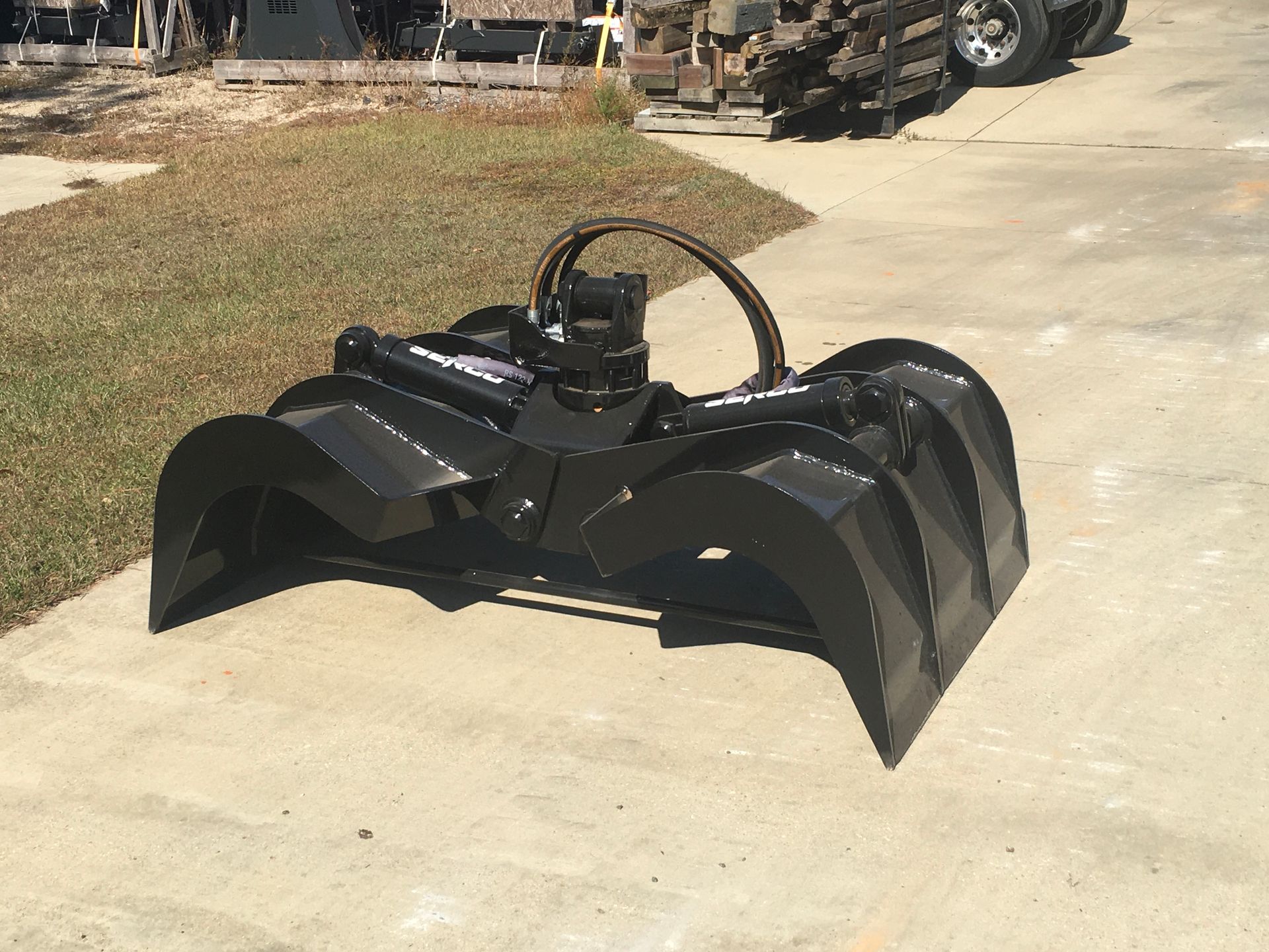 A black bucket with a hose attached to it is sitting on a sidewalk.