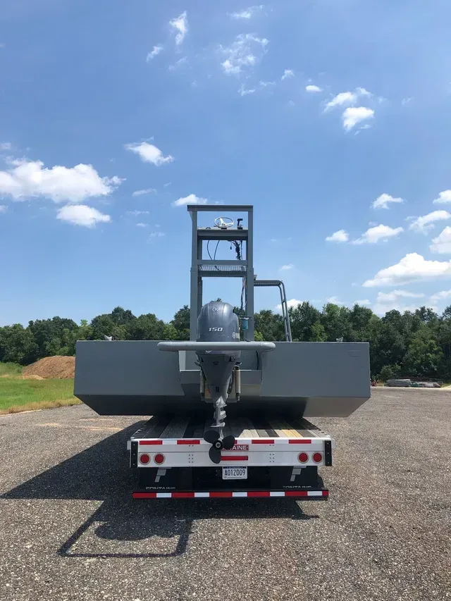 A boat is sitting on top of a trailer in a parking lot.