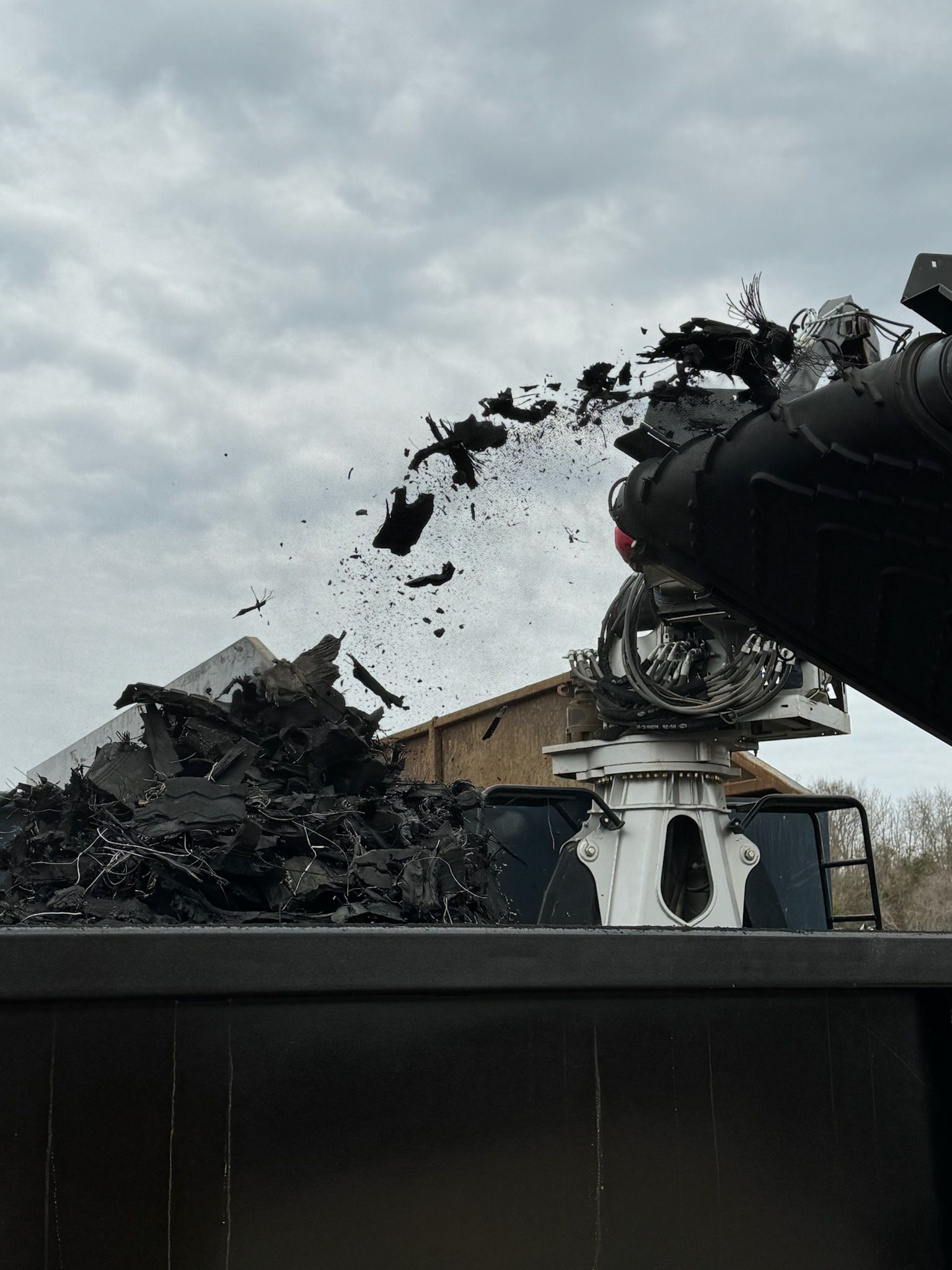 A pile of scrap metal is being loaded into a truck for debris removal services