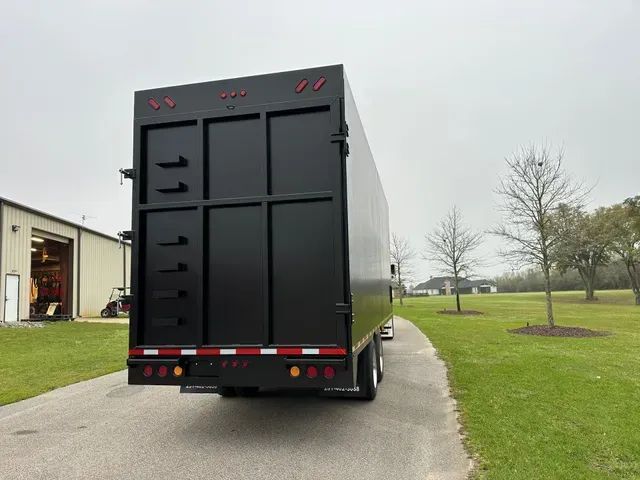 A black truck is parked on the side of a road.