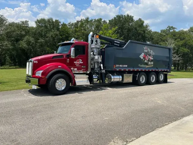 A red dump truck is parked on the side of the road.