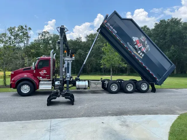 A dump truck with a crane attached to it
