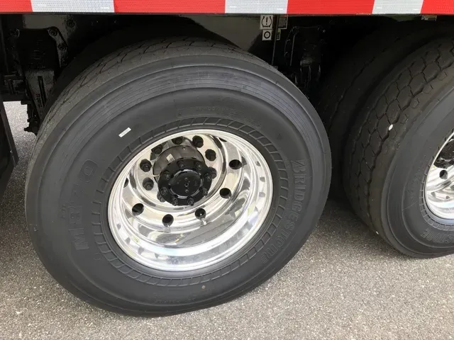 A close up of a truck tire on a road.