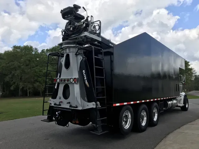 A large black truck is parked on the side of the road.