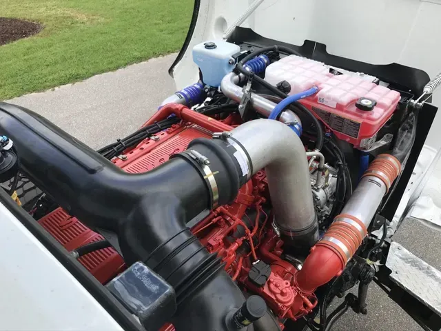 A close up of a red engine on a white truck