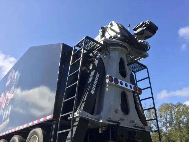 A large truck with a crane attached to it is parked on the side of the road.