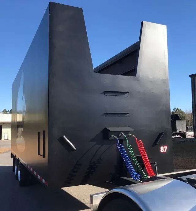 A large black trailer with the number 87 on it