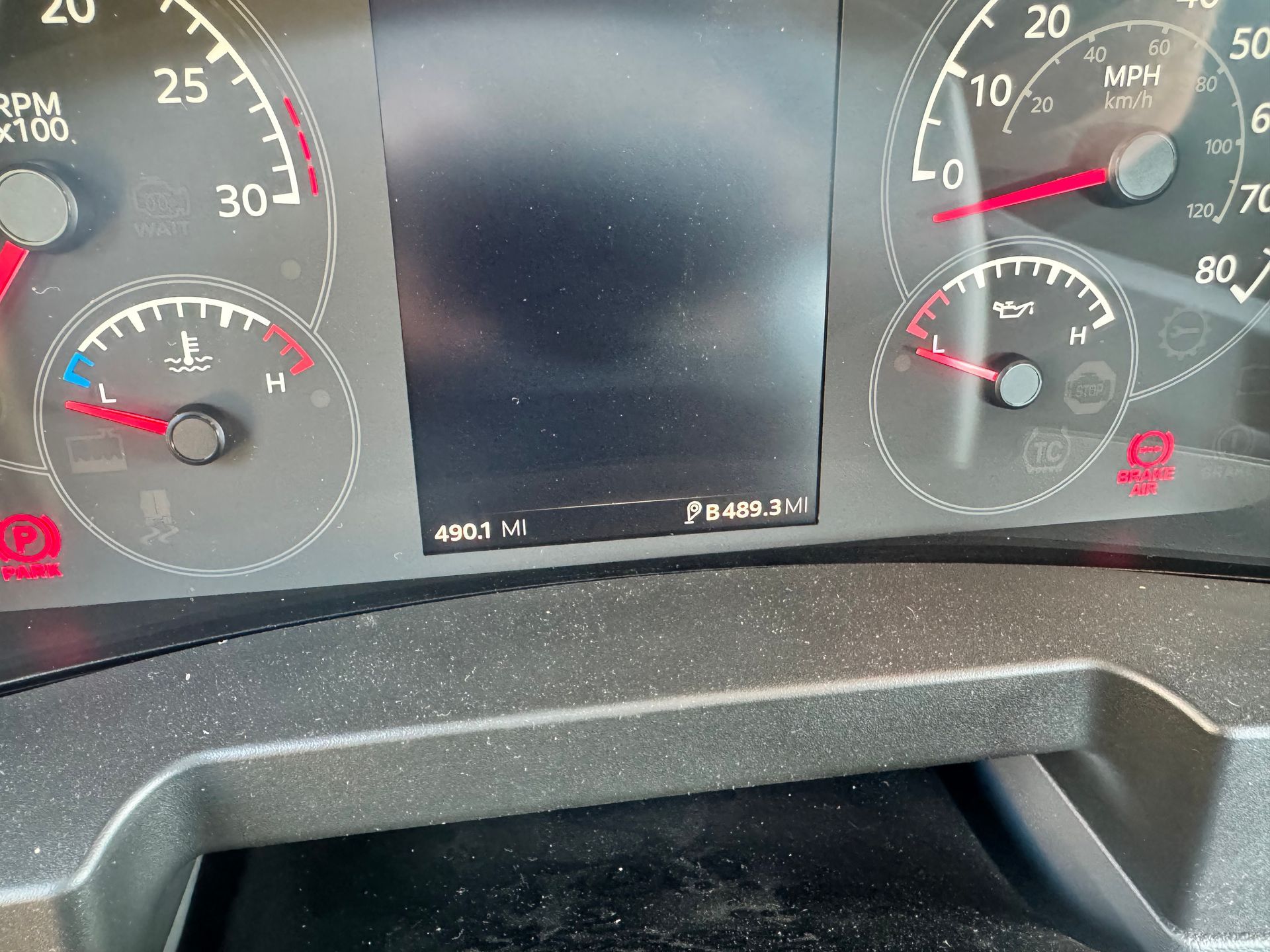 Dashboard of a vehicle showing gauges, including speedometer and fuel level.