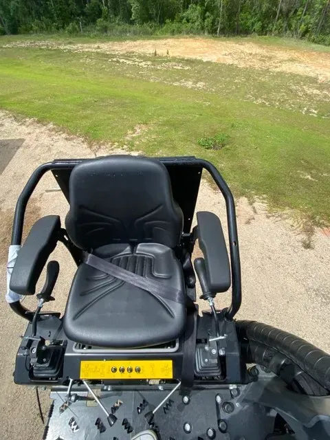 A black tractor is parked in a grassy field