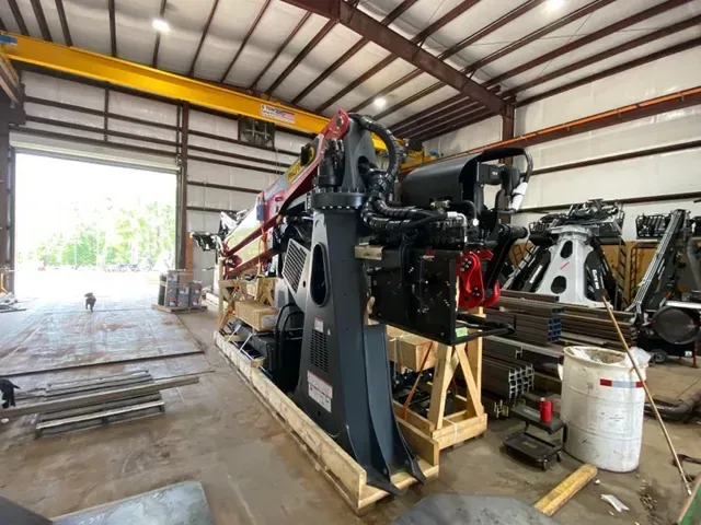 A large machine is sitting on top of a wooden crate in a garage.