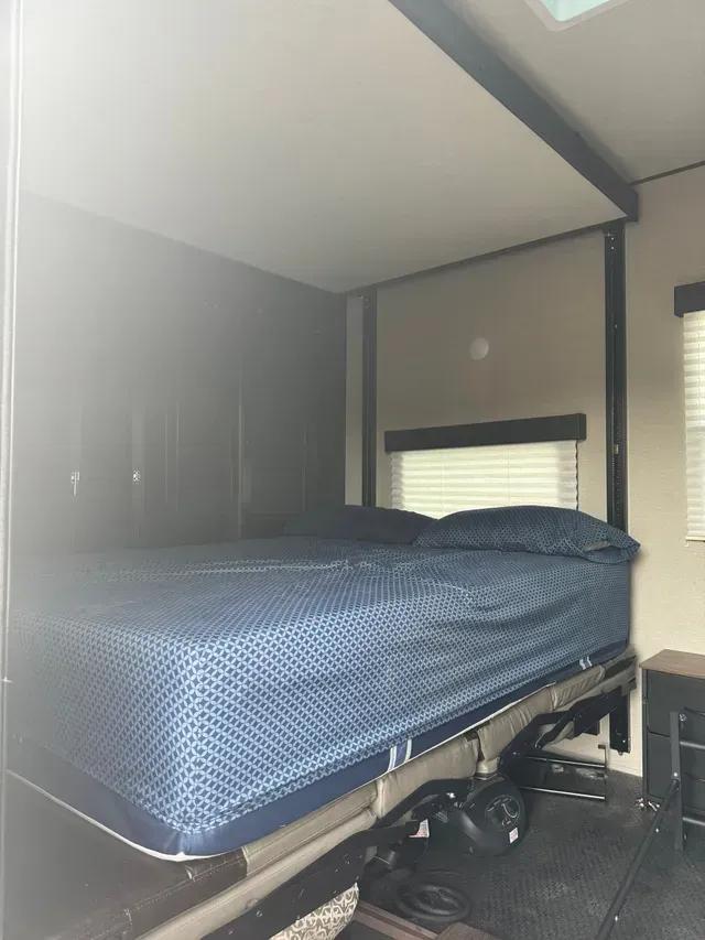 A bedroom with a blue bed and a window