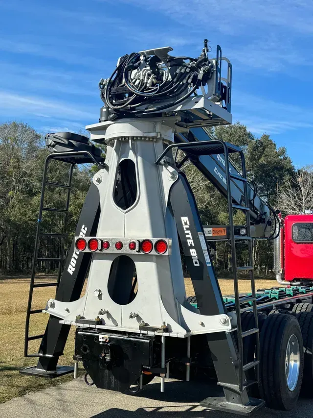 A large crane is attached to the back of a semi truck.