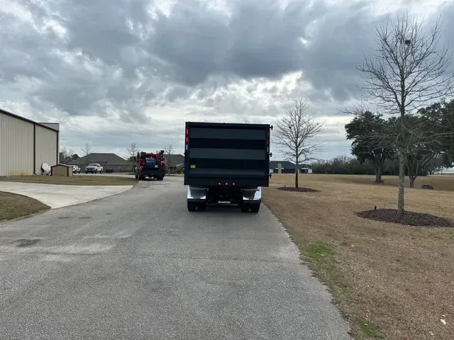 A dump truck is parked on the side of a road.