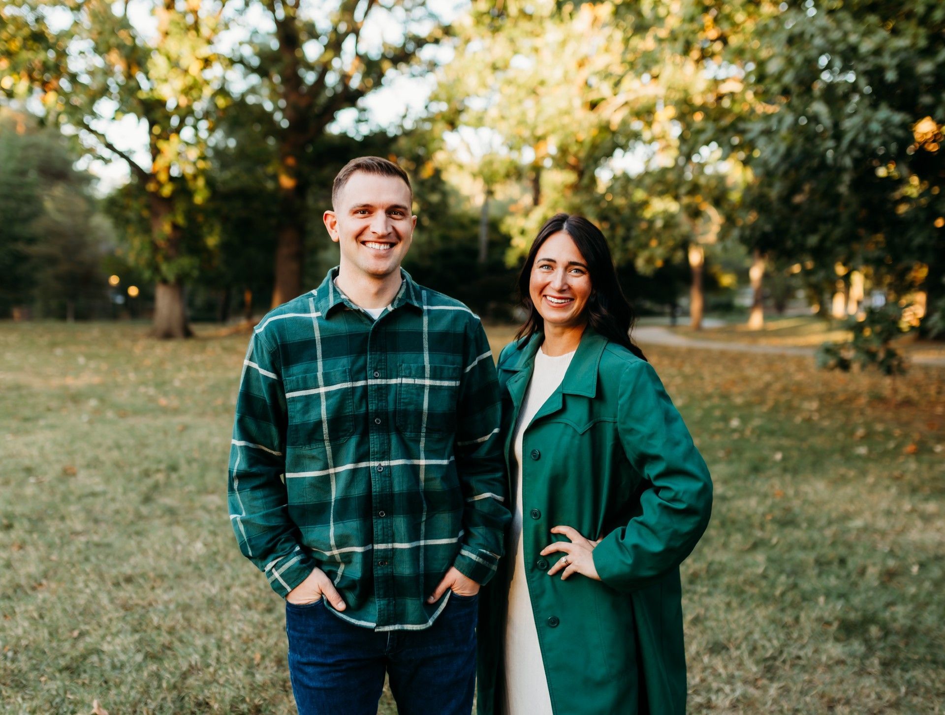 A man is sitting in a chair next to a woman standing next to him.
