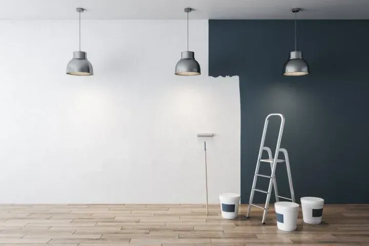 Modern room featuring a half-painted dark grey accent wall.