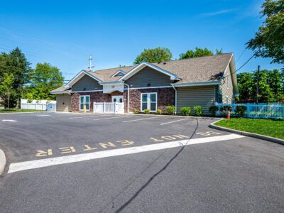 A large house with a parking lot in front of it.