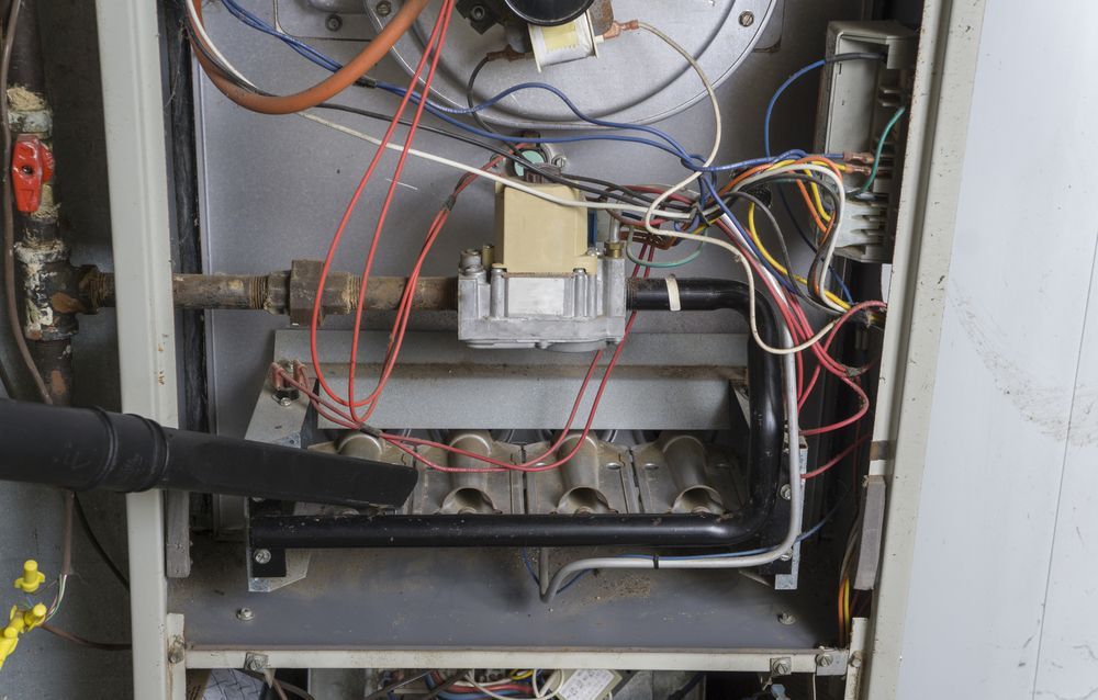 Open electrical panel with wires, circuit components, and metal frame inside a machine cabinet.