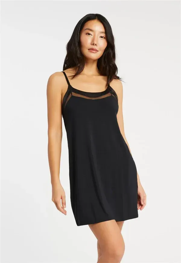 Woman in black slip dress with lace trim.