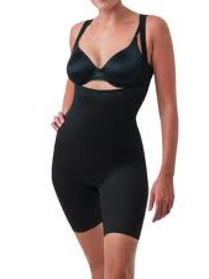 Woman wearing black shapewear, posing with hand on hip.