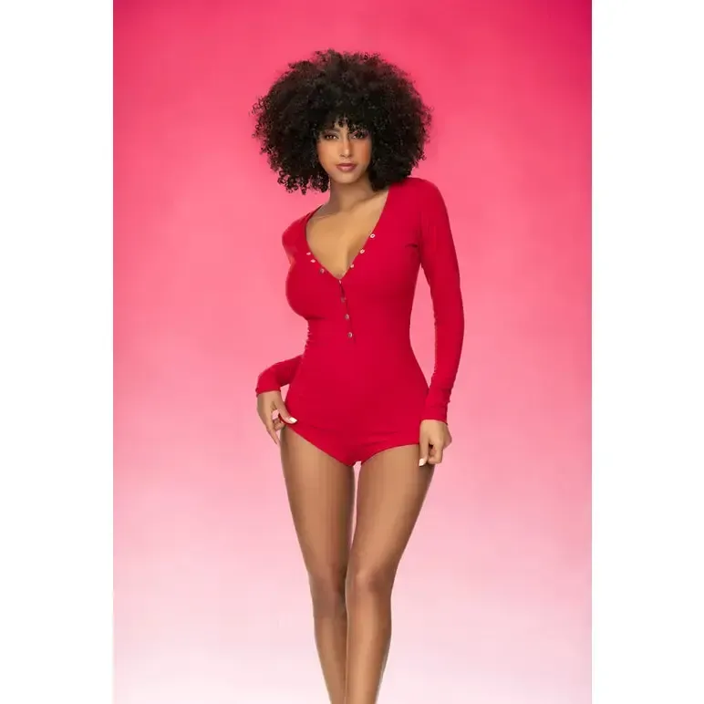 Woman in a red onesie with an afro, posing against a pink background.
