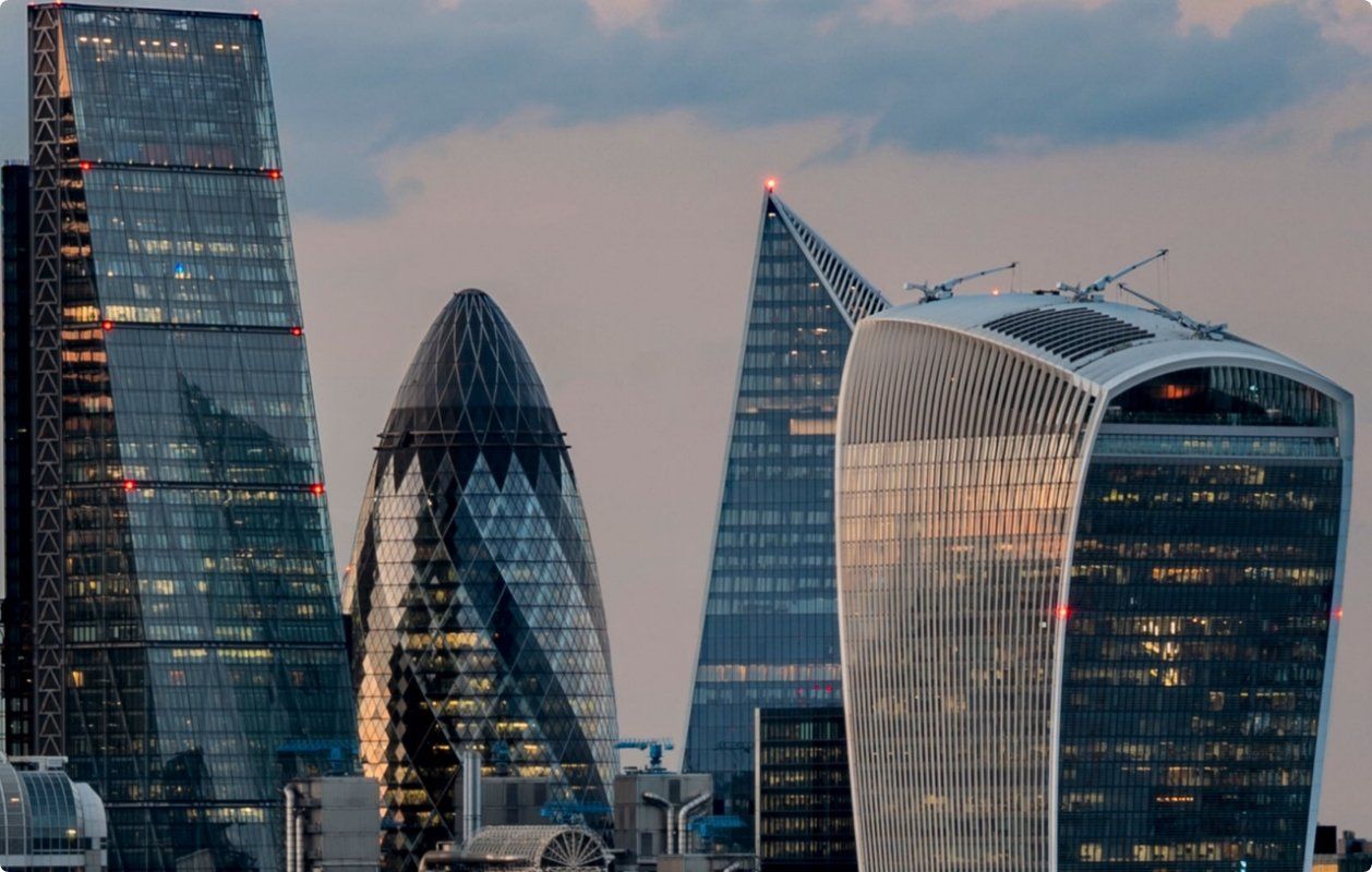 A group of tall buildings in a city with a cloudy sky in the background in United Kingdom.
