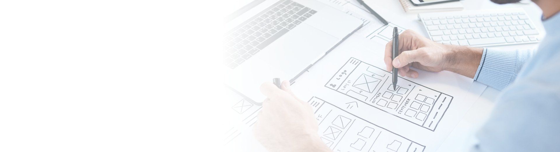 A man is drawing on a piece of paper with a pen.