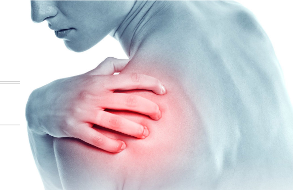 A woman is holding her shoulder in pain.