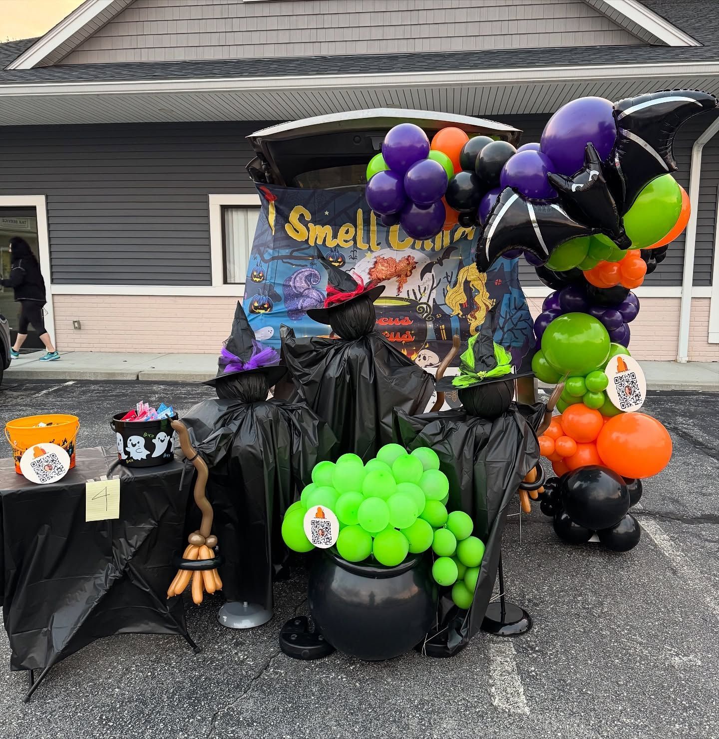Halloween display with black, purple, orange, and neon green balloons around a spooky Smells banner